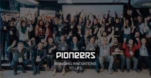 Pioneers Text Logo with Many people lifting up their hands in the background